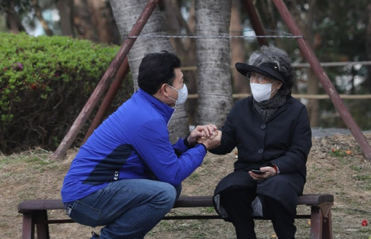 지난달 27일 부산 해운대구 동백섬에서 더불어민주당 송영길 의원이 시민을 만나 김영춘 부산시장 후보 지지를 당부하고 있다. <연합뉴스>